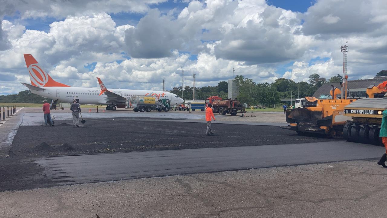 Pavimentação asfáltica no pátio de manobras do Aeroporto Mamed Cameli, em Cruzeiro do Sul, com aeronave ao fundo